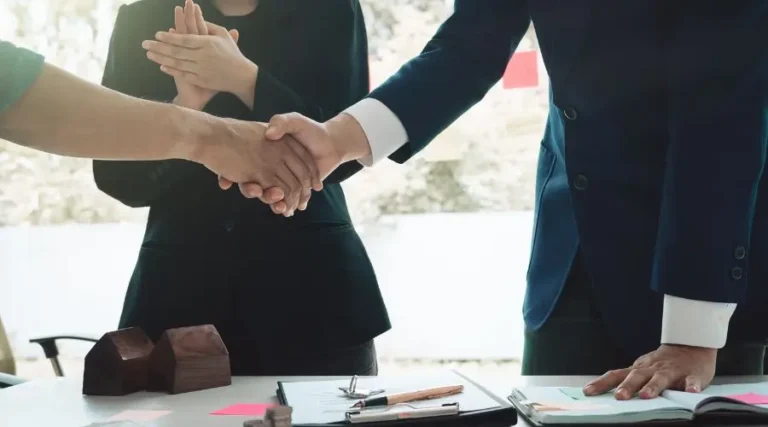 Poignée de mains entre un client et l'équipe de son agence immobilière à Gatineau